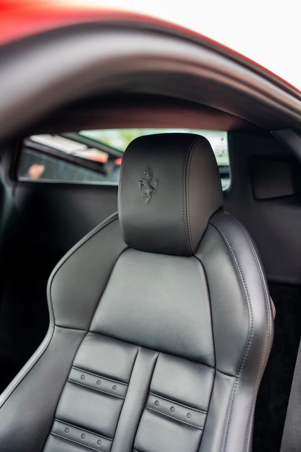 Schwarzer Ledersitz des Ferrari 458 Italia mit eingeprägtem Cavallino Rampante