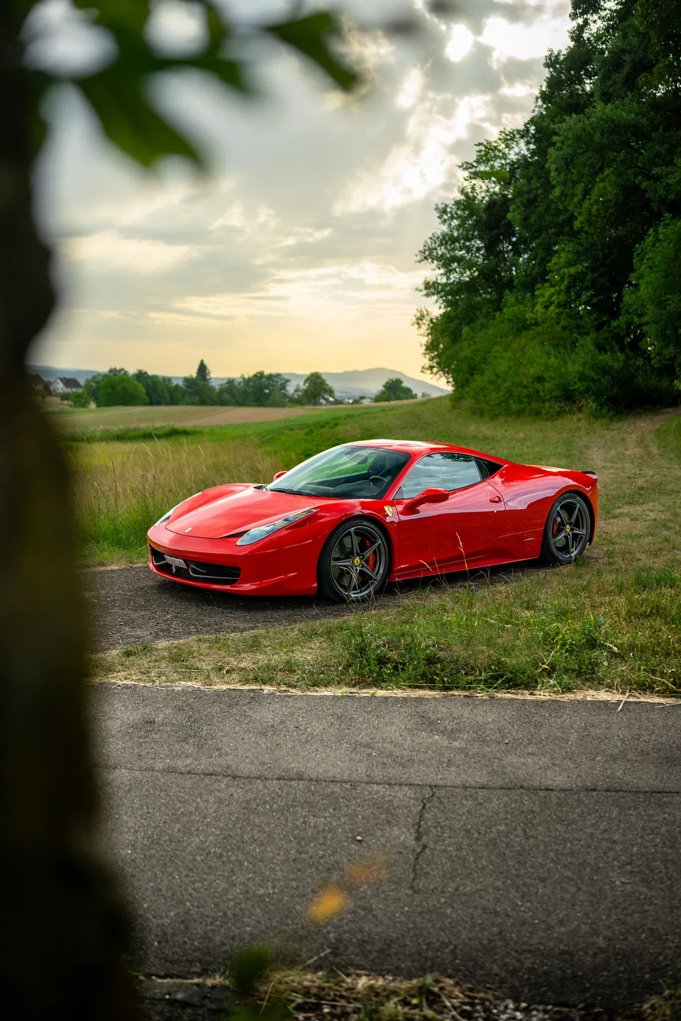 Ferrari 458 Italia zwischen Bäumen in der Schweizer Landschaft