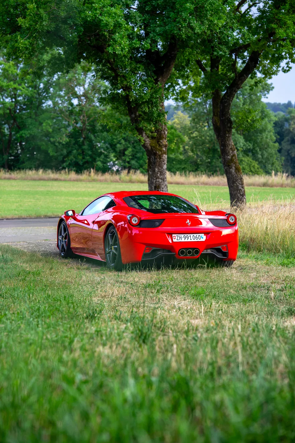 Heck-Dreiviertelansicht des Ferrari 458 Italia unter einem Baum