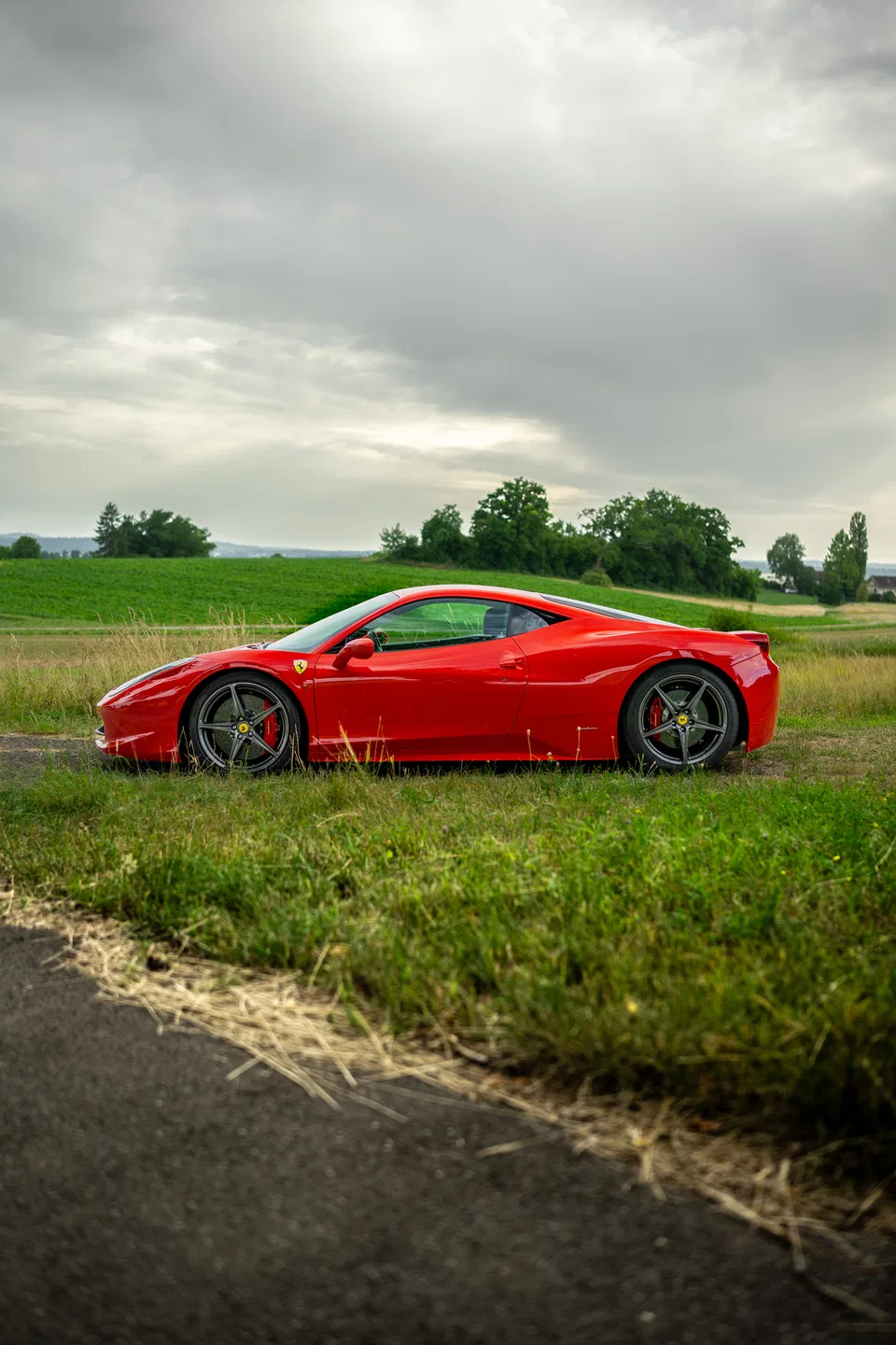 Seitenprofil des Ferrari 458 Italia neben offenen Feldern